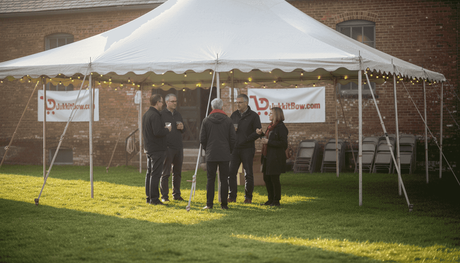 Een groep mensen verzamelt zich onder een feesttent.