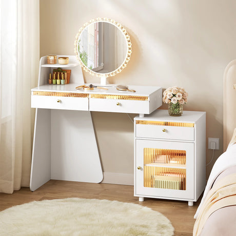 Witte kaptafel met verlichte ronde spiegel, drie lades en zijkast naast een bed