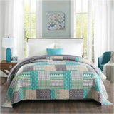 Moderne grijze omkeerbare bedsprei van BukkitBow met patchwork patroon, verkrijgbaar in verschillende maten.