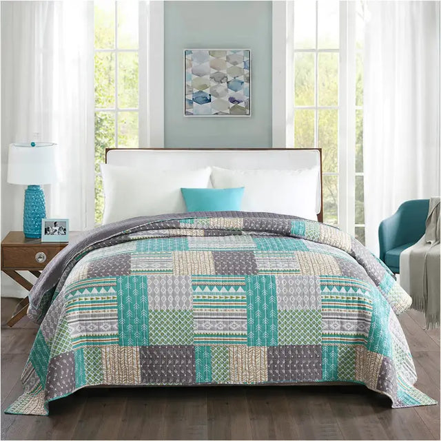 Moderne grijze omkeerbare bedsprei van BukkitBow met patchwork patroon, verkrijgbaar in verschillende maten.