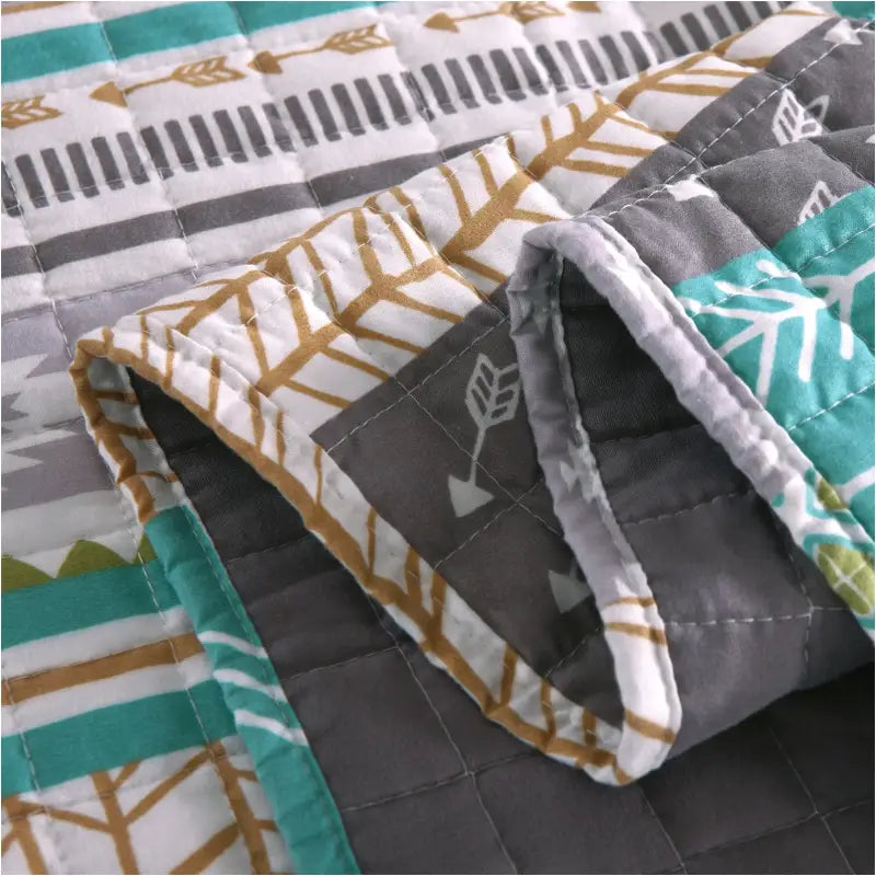 Moderne BukkitBow bedsprei met omkeerbaar grijs en patchwork patroon, afgebeeld in verschillende maten, comfortabel en stijlvol.