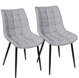 Set van 2 BukkitBow eetkamerstoelen met leren, stoffen en fluwelen bekleding, metalen poten en ergonomisch ontwerp.