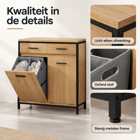 Wasmandkast van licht eiken en zwart met twee uitneembare waszakken en twee lades, weergegeven in close-up.
